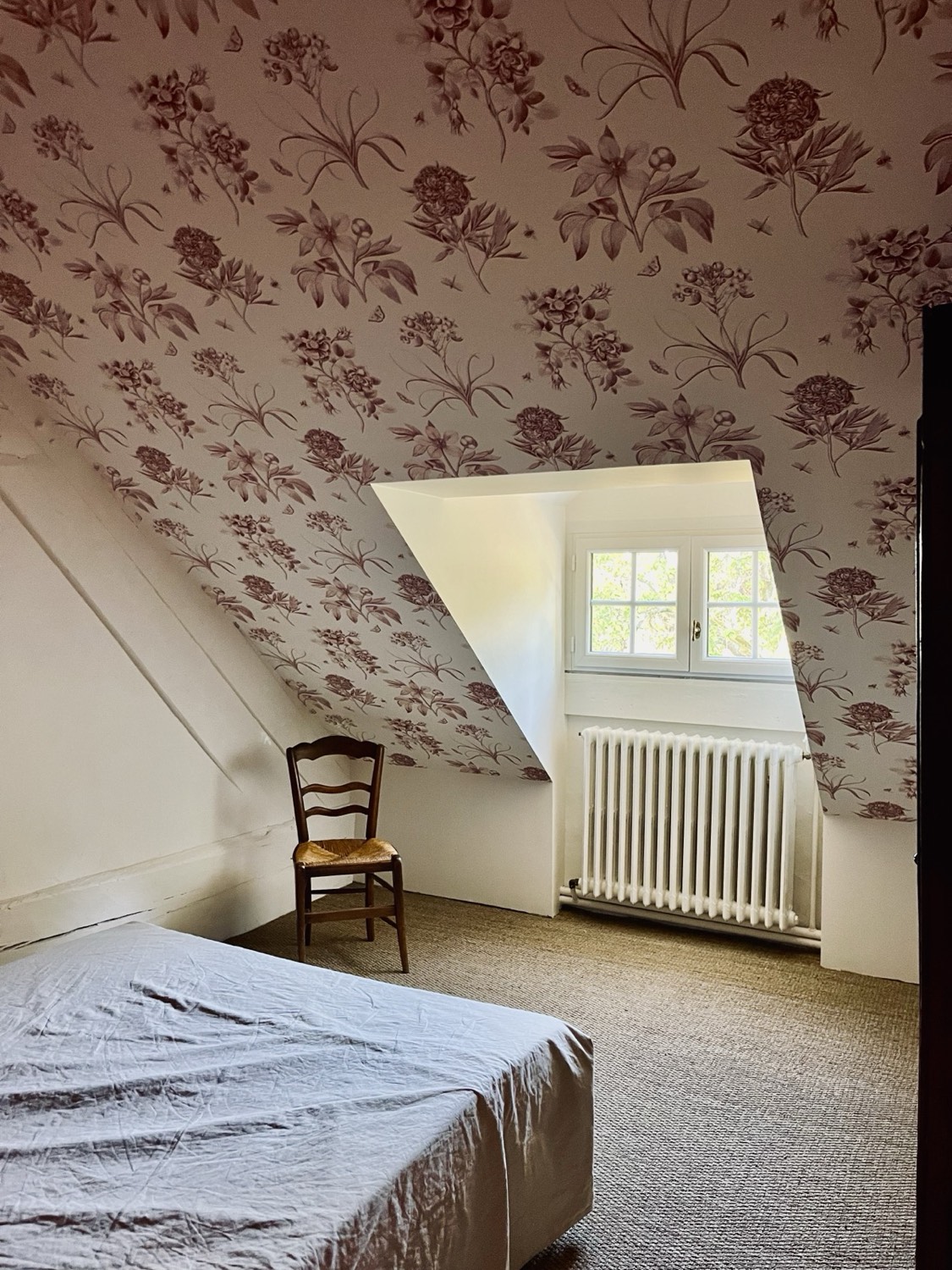 Slaapkamer met bloemetjesbehang, op zolder