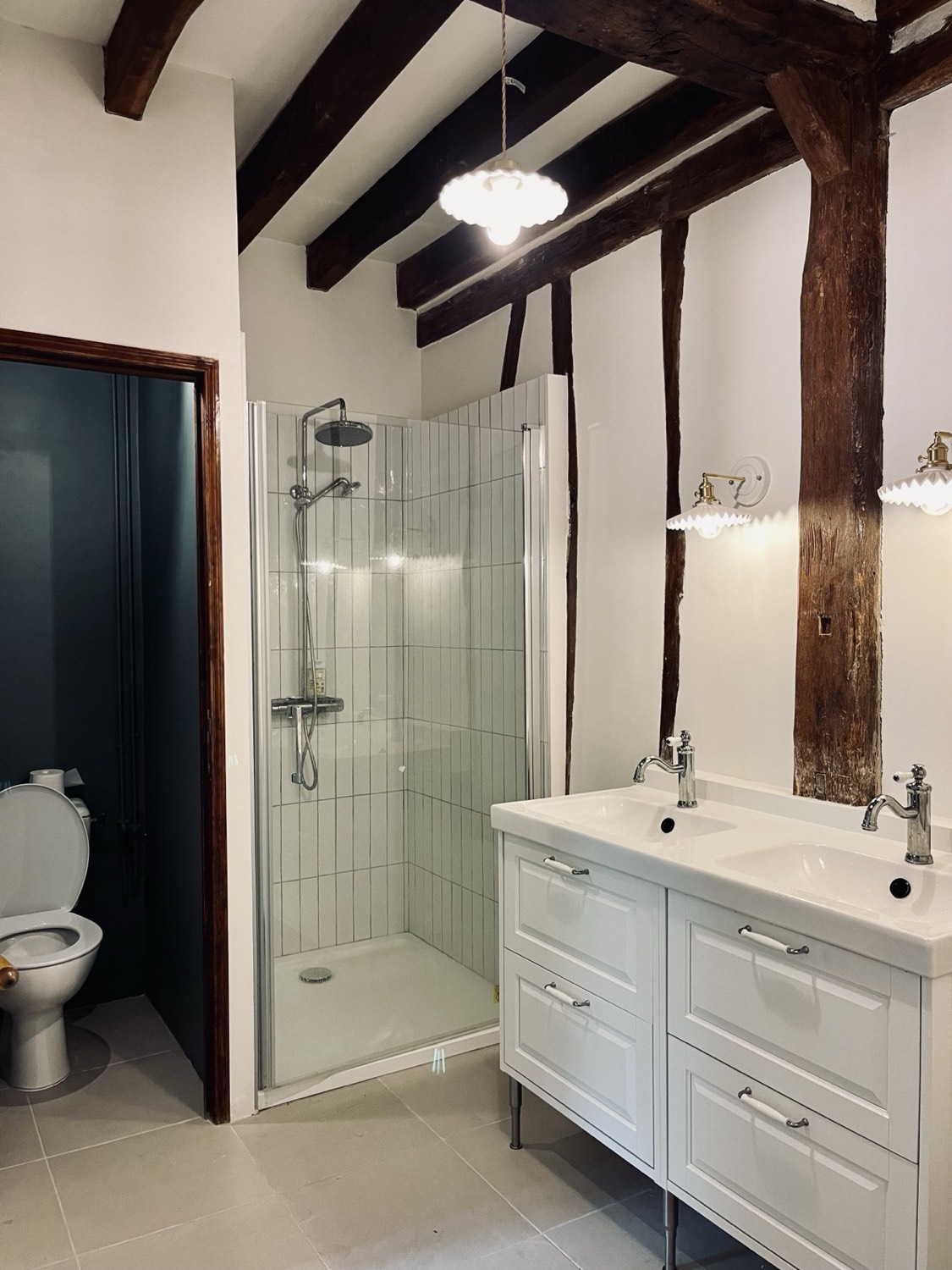 Badkamer onder de kapconstructie, met douche en dubbele wastafel
