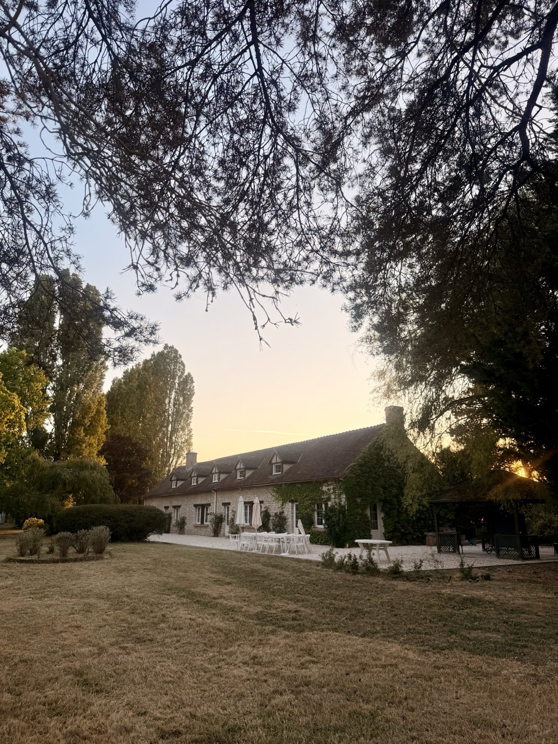 De gevel van de boerderij bij zonsondergang