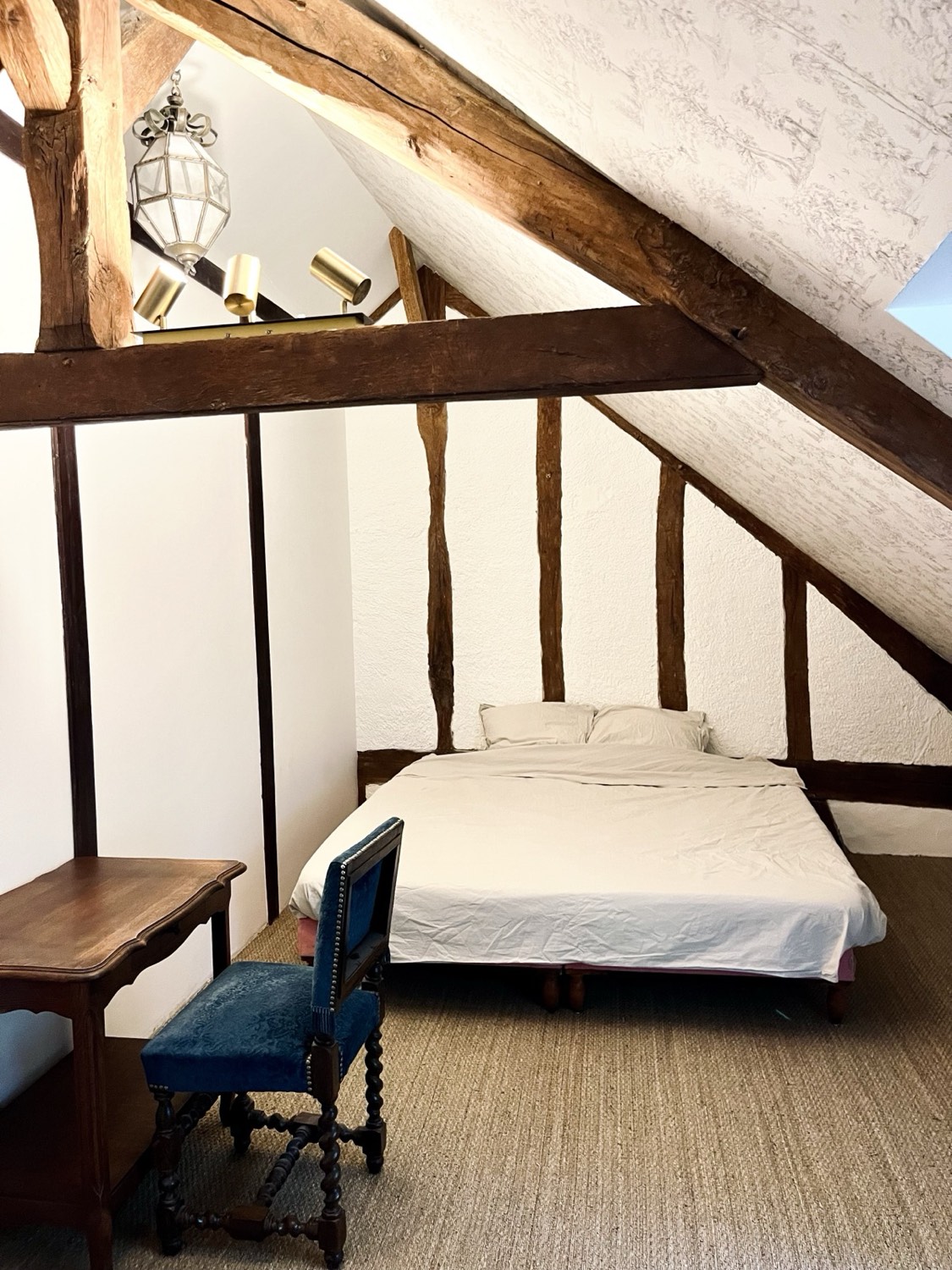 Romantische slaapkamer onder de oude houten kapconstructie