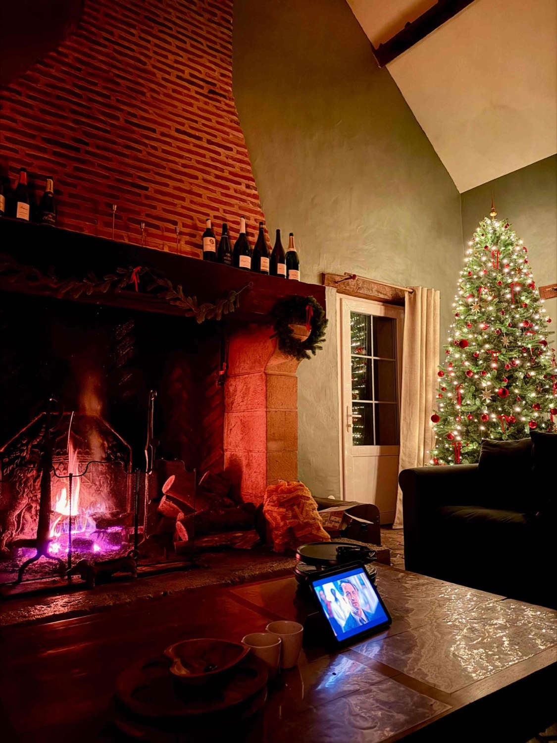 De woonkamer in kersttijd, met haardvuur en verlichte kerstboom