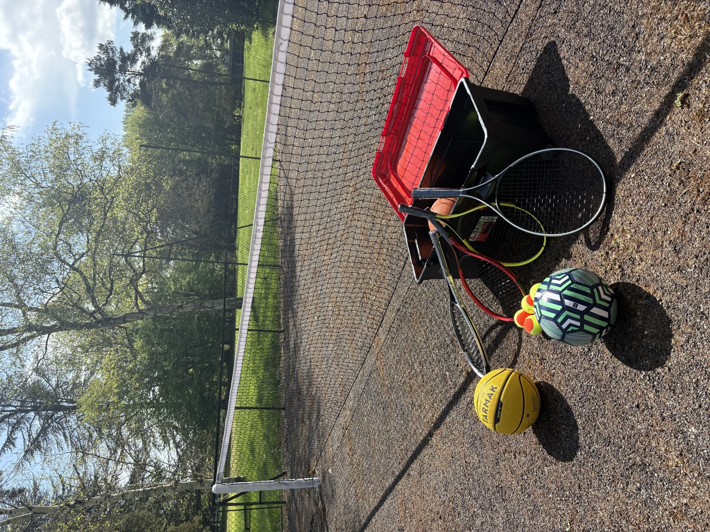 L'ancien court de tennis réhabilité en terrain de jeux : filet, raquettes et ballons
